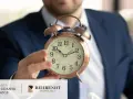 Mężczyzna w garniturze trzyma budzik. Czas ucieka, a kredyt frankowy przedawnienie to ważna kwestia prawna.