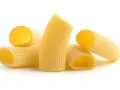 Kilka kawałków makaronu rigatoni, z charakterystycznymi rowkami, gotowych do sosu.