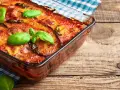 Parmigiana di melanzane in friggitrice ad aria, dorata e profumata, guarnita con basilico fresco. Un piatto gustoso e leggero.