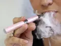 Persona usa un vapeador para dejar de fumar, exhalando una gran nube de vapor.