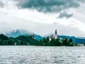 Jezioro Bled ze słynną wyspą i kościołem to obowiązkowy punkt, co warto zobaczyć w Słowenii. W tle góry.
