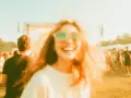 Szczęśliwa dziewczyna w okularach na festiwalu, gdzie grają wszystkie baciary piosenki. Tłum ludzi bawi się przy muzyce.