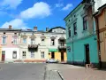 Kolorowe kamienice przy ulicy, gdzie mój stryj kiedyś mieszkał. Srebrny samochód zaparkowany obok apteki.