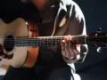 Gitarrist übt den **palm mute**-Effekt auf einer Akustikgitarre, die Finger liegen auf den Saiten.