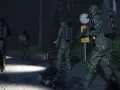 Żołnierze w kamuflażu i robot zwiadowczy na nocnej drodze leśnej.