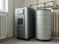 Nowoczesny piec na pellet obok zasobnika, który działa jak bufor ciepła, gromadząc energię do ogrzewania domu.