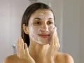 Frau mit Schaum im Gesicht, die ihre Haut reinigt. Ein Schritt im Double Cleansing für reine Haut.