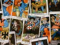 Rozłożone karty tarota, w tym "Le Pape" i "Le Mat". Wśród nich widać fragmenty innych kart, sugerujące wróżbę o karcie głupiec w miłości.