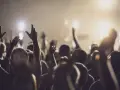 A crowd with raised hands, bathed in warm light, as if in a moment of shared worship or during powerful christian chants.