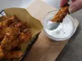 Bocconcini di pollo in friggitrice ad aria, croccanti e dorati, pronti per essere intinti in una salsa cremosa.