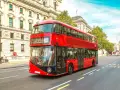 Ikoniczny czerwony autobus piętrowy na ulicy w Londynie, symbol komunikacji miejskiej.