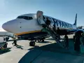 Ryanair samolot, pasażerowie wsiadają. Pamiętaj o zasadach, jak przewozić leki w samolocie Ryanair, by podróż przebiegła sprawnie.