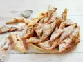 Faworki croccanti e dorati, spolverati di zucchero a velo. Un delizioso dolce da preparare seguendo un semplice faworki przepis.