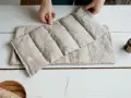 Mains tenant une bouillotte graines de lin, prête à soulager les tensions. Un objet doux et naturel pour le bien-être.