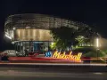 Insegna luminosa KTM Motohall di notte, con il moderno edificio illuminato e le scie luminose delle auto.