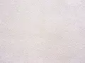 Texture d'un corps d'enduit chaux blanc, légèrement granuleux, évoquant la fraîcheur et la pureté d'une façade traditionnelle.
