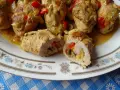 Roladki schabowe z kolorowym farszem warzywnym w sosie na talerzu.