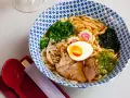 Miseczka zupy ramen z makaronem, jajkiem, mięsem, warzywami i nori.