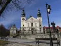Kalwaria Zebrzydowska zwiedzanie: barokowy kościół z wieżami, kapliczki, ławki i pomnik.