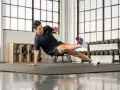 Un homme en tenue de sport exécute un exercice de planche latérale dans une salle de sport.