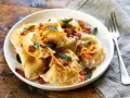 Pyszne pierogi z boczkiem i cebulką, idealne na obiad. Dowiedz się, ile gotować pierogi, by były idealne.