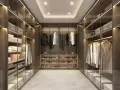 Cabina armadio aperta o chiusa, con abiti ordinati su mensole e grucce, scarpe esposte e scatole contenitive.