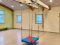 Therapieschaukel für Kinder im Test. Die Schaukel hängt von einer Deckenkonstruktion herab und ist bereit für den Einsatz.