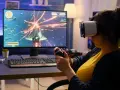 Kobieta w goglach VR gra w kosmiczną strzelankę, testując swoje umiejętności w ramach studiów game design.