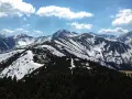 Majestatyczne Tatry w kwietniu, pokryte śniegiem szczyty i zielone lasy.