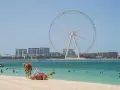 Plaża w Dubaju z wielkim kołem widokowym w tle. Czy do Dubaju trzeba paszport? Tak, ale widok jest wart podróży!