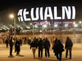 Tłum ludzi zmierza do Tauron Areny Kraków na koncert. Wielki napis na dachu obiektu zapowiada wydarzenie. To prawdziwy **rush w Polsce**!