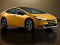 Złoty Toyota Prius Plug-in Hybrid z czarnym dachem, nowoczesnymi światłami i stylowymi felgami.