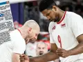 Daniel Stępień, siatkarz w białej koszulce z numerem 9 i godłem Polski, świętuje z kolegą z drużyny.
