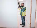 Budowlaniec sprawdza poziom otwarcia pod drzwi 90.