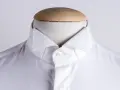 Dettaglio di una camicia bianca su un manichino, che mostra i diversi tipi di colletto camicia.
