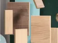 Muestras de madera con veta marcada, algunas con texturas lineales y otras lisas, sobre fondos de colores.