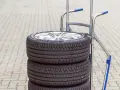 Stos czterech opon samochodowych na wózku. Zastanawiasz się, ile waży opona samochodowa?