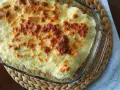 Parmentier de patata gratinado en fuente de cristal, con queso dorado y burbujeante. Un plato reconfortante y delicioso.