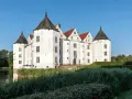 Wasserschloss in Schleswig-Holstein, ideal für die herbstferien 2025. Ein malerisches Schloss mit Türmen und Wassergraben.