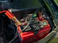 Jump starter cables connected to a car battery. This shows how a jump starter can charge a battery to get your car running again.
