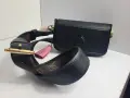 Elegancka, czarna louis vuitton torebka z ozdobnym, różowym pomponem i paskiem z monogramem.