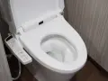 Panneau de commande d'une toilette japonaise. Il montre les options de nettoyage et de séchage, illustrant le fonctionnement de cet appareil moderne.