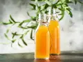 Dwie butelki z domową kombuchą, idealne do nauki jak zrobić grzyb kombucha.