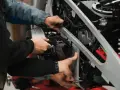 Mechanicy montują nowy filtr powietrza w motocyklu. Zepsuty filtr powietrza objawy to m.in. spadek mocy.