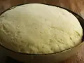 Puszyste ciasto na pizzę w misce, gotowe do pieczenia. Dowiedz się, jak rozmrozić ciasto na pizzę, by było idealne.