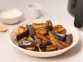 Berenjenas en freidora de aire, doradas y crujientes, listas para disfrutar con un dip cremoso.