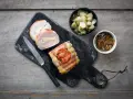 Un délicieux roti de porc Orloff, tranché et garni, accompagné de légumes et d'une sauce onctueuse.