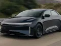 Ciemnoniebieski Lucid Air Sapphire pędzi po drodze, jego aerodynamiczna sylwetka i futurystyczne światła przyciągają wzrok.