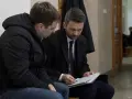 Prawnik omawia z klientem dokumenty dotyczące dobrowolnego poddania się karze a warunkowego umorzenia postępowania.