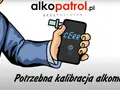 Dłoń w garniturze trzyma alkomat z napisem "CERR".